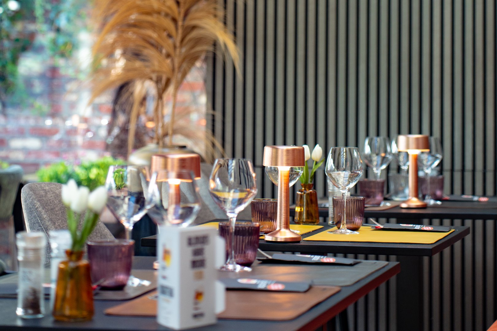 Cozy dining space with copper lamps and elegant table settings